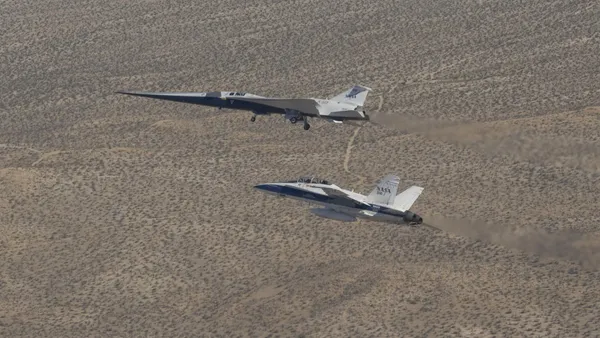 Un caccia F/A-18 in volo accanto allo sperimentale X-59 della NASA