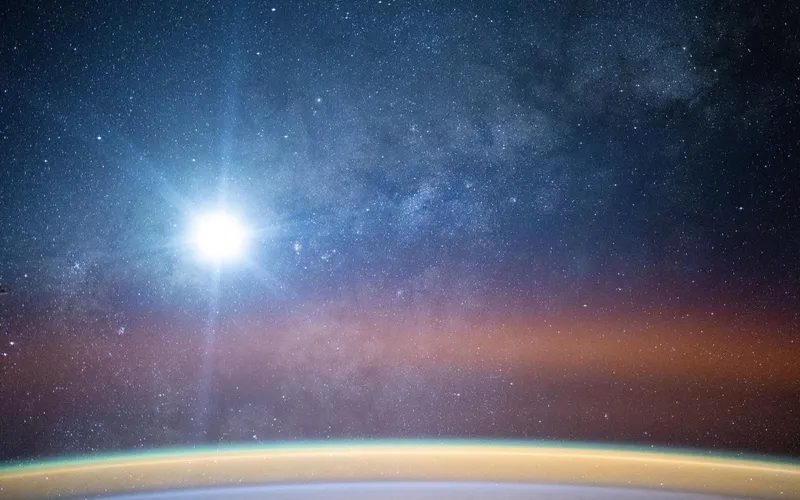 La Via Lattea illumina il cielo notturno sopra l'orizzonte terrestre